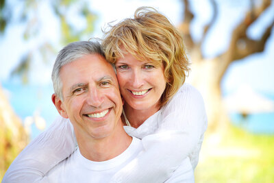 mature couple smiling near lake outdoors Cedar City, UT dental implants