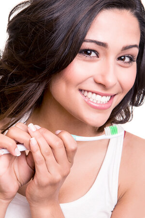 woman smiling long dark hair nice white teeth, holding toothbrush. Cedar City, UT preventive dentistry